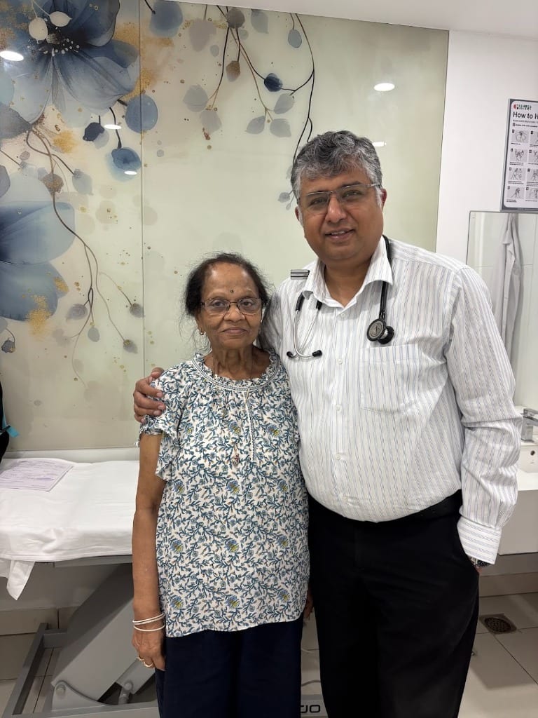 Cardiac patient smiling alongside Dr. Manish Aggarwal in his consultation room following recovery from emergency stenting